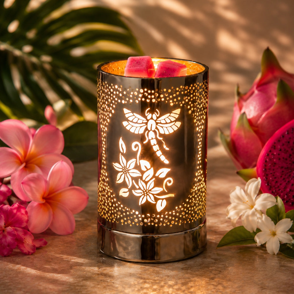 Wax warmer with a dragonf fly floral design surrounded by flowers on a wooden surface