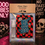Mmma Bears Scent Boutique air freshener gift set in a clear holographic plastic bag with a kraft paper header card. The set includes a small clear spray bottle and a rectangular air freshener card featuring a red and black checkered pattern, blue text reading 'BUT DID YOU DIE?', and colorful cartoon flowers.