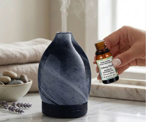 Marble-patterned diffuser with a hand holding an essential oil bottle on a neutral background