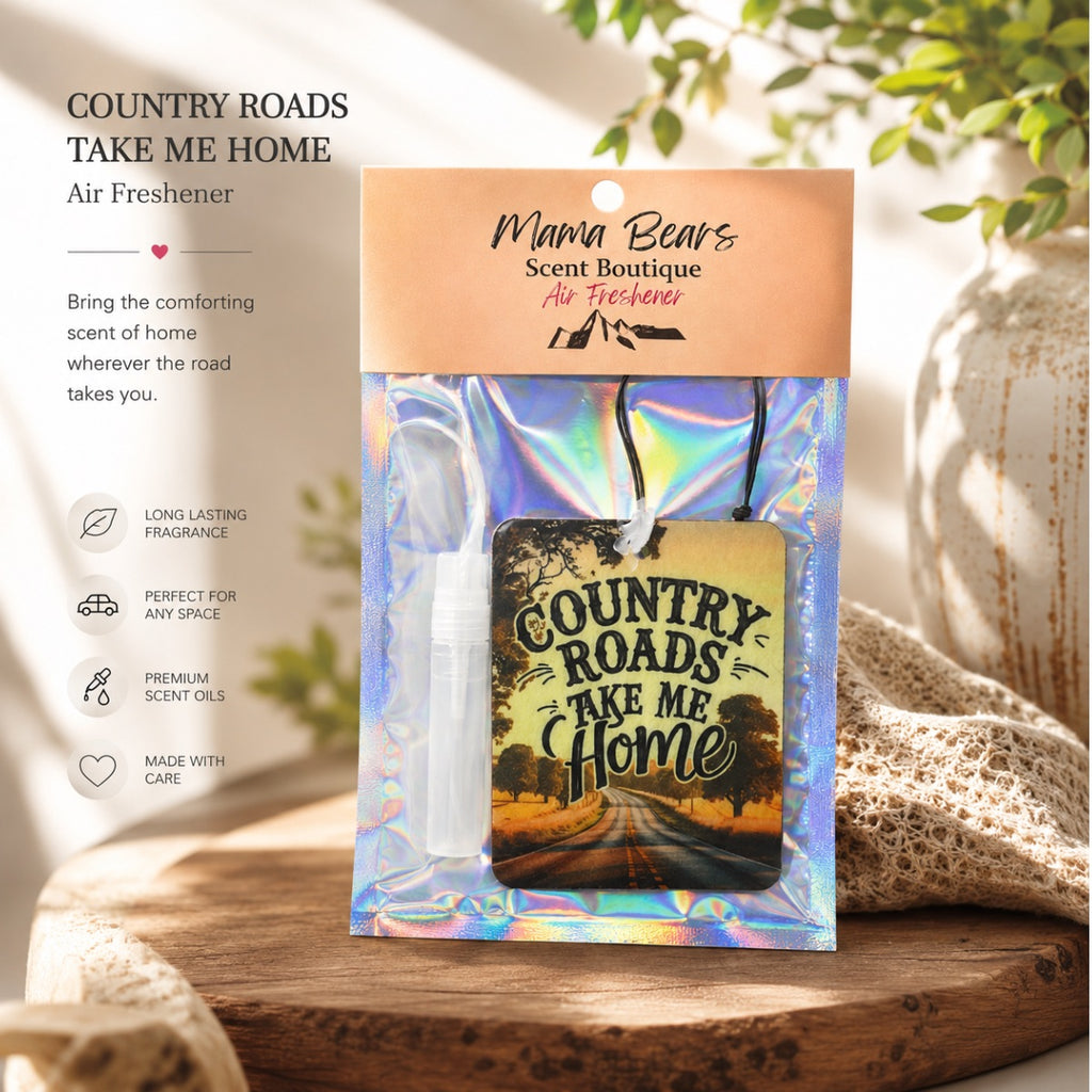 Air freshener packaging with 'Country Roads Take Me Home' design on a wooden surface.