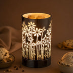 A wax melt warmer with floral pattern on a brown background with cookies and ice cream.