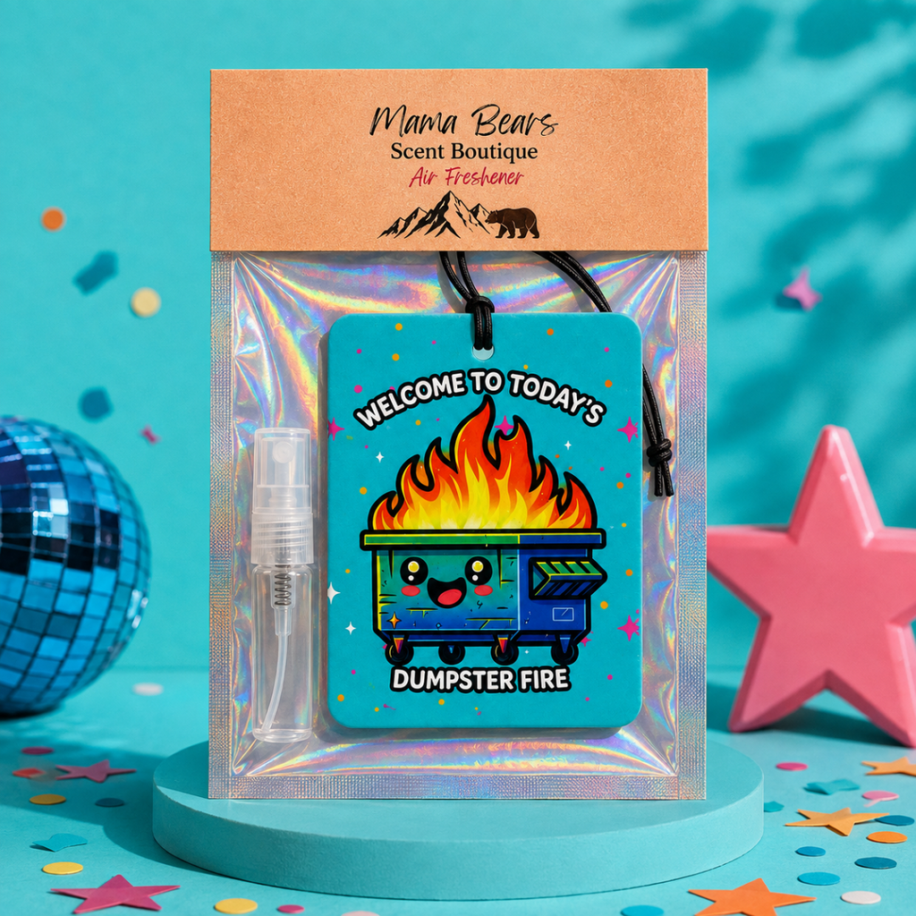 A packaged air freshener set from Mama Bears Scent Boutique featuring a blue dumpster fire graphic tag, a small clear spray bottle, and an iridescent sleeve on a teal background with confetti and decorative props.