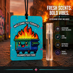 A novelty car air freshener or perfume tag labeled 'WELCOME TO TODAY'S DUMPSTER FIRE' with a cartoon dumpster on fire, shown next to a small clear spray vial. The background is a blurred street scene at sunset, and the right side includes marketing text and icons about lasting fragrance and travel-friendly design.