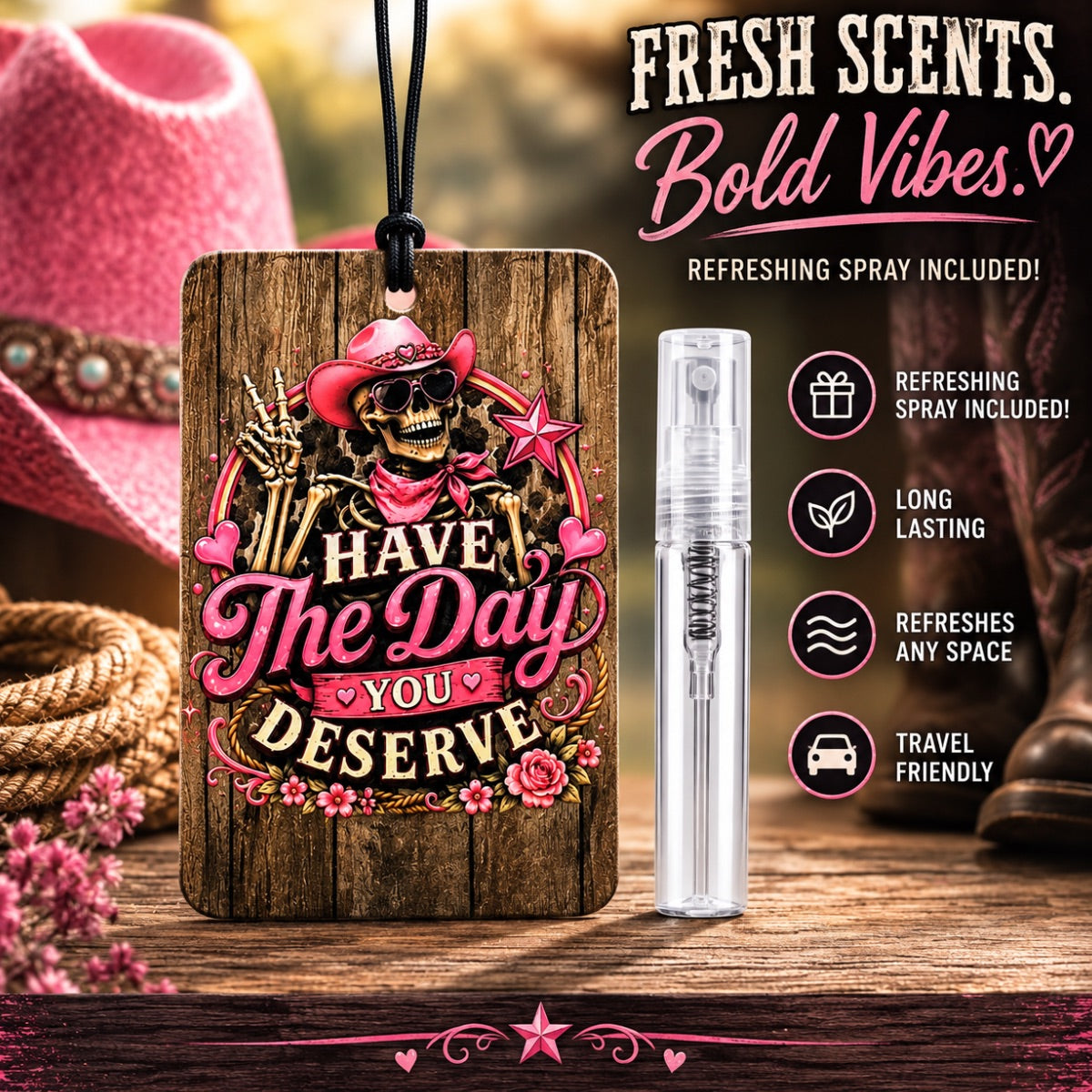 A wooden car fragrance tag with a western-themed skull and rose graphic reading 'HAVE THE DAY YOU DESERVE,' shown next to a small clear spray bottle. The scene includes a pink cowboy hat, rope, boots, and a blurred outdoor background, with text advertising 'Fresh Scents.