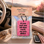 Air freshener with humorous message in a car interior