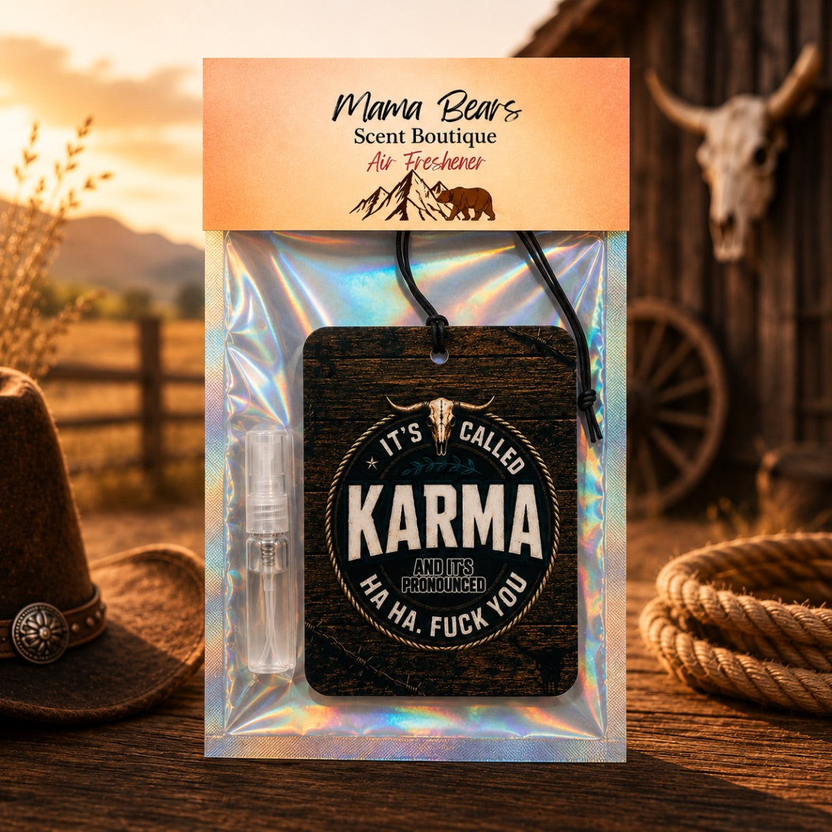 Mama Bear's Scent Boutique Air Freshener package featuring a dark wood-grain 'Karma' air freshener tag with a cow skull graphic, a small clear spray bottle, and an iridescent holographic backing card, set against a rustic western-themed background.