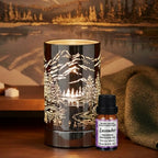 Diffuser oil/wax warmer with mountain design next to a bottle of lavender diffuser oil on a wooden surface with a scenic background.