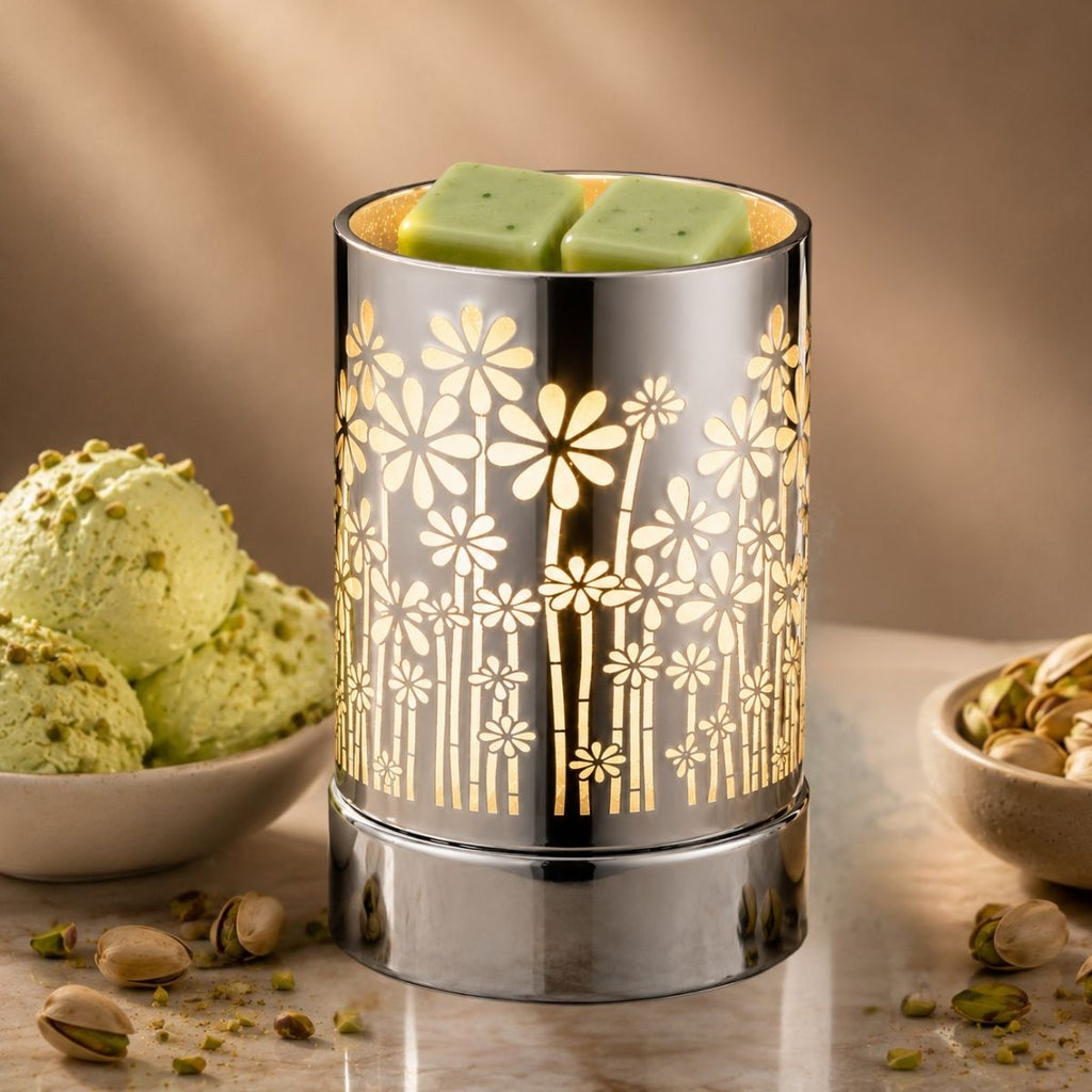 Decorative wax warmer with floral design on a table with pistachio-themed items.