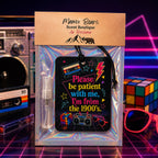 A packaged air freshener from Mama Bears Scent Boutique, featuring a retro 1990s-themed black card with colorful text and graphics, a clear spray bottle, and a kraft paper header card, displayed against a neon grid background with vintage electronics and a Rubik's cube.