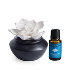 Porcelain diffuser with white flower and peppermint oil bottle on a white background